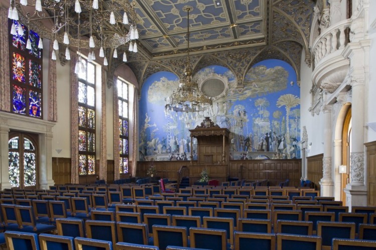 Het interieur overzicht van de Aula (Academiegebouw Groningen). De muurschildering 'De boom der kennis' (1987) is van de Groningse kunstenaars Matthijs Röling en Wout Muller. Bron Wikipedia